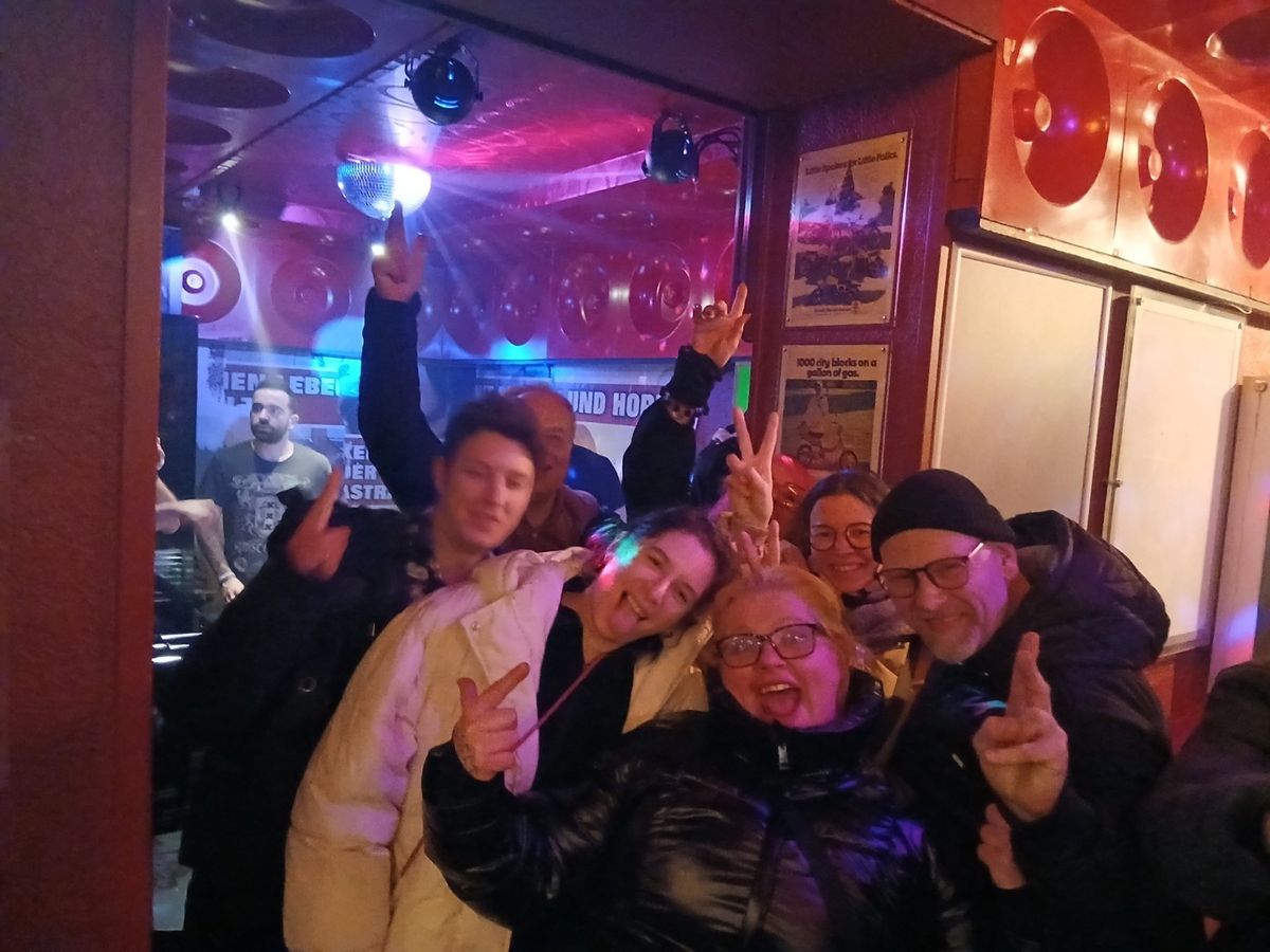 Susa mit einer jubelnden Gruppe in einer Bar